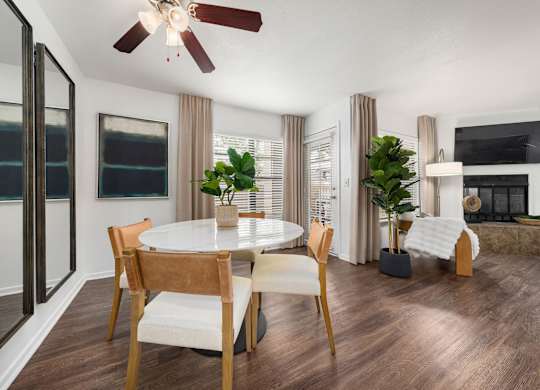 A modern dining room with a round table and chairs.