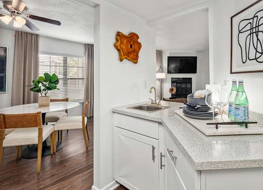 A kitchen with a white countertop and a wooden chair.