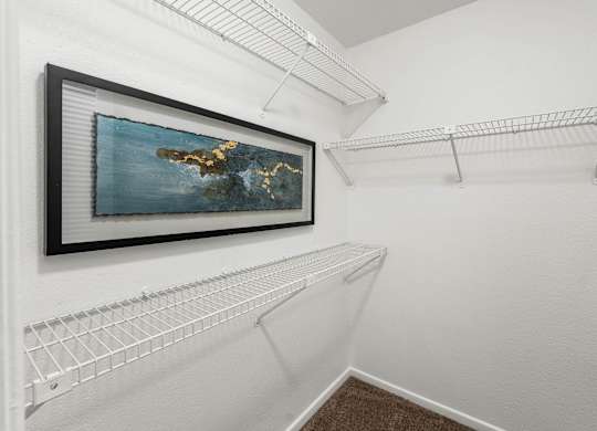 A picture of an island is hanging on a wall above a shelf.