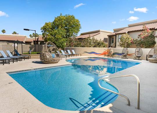 A swimming pool with a slide and sun loungers.