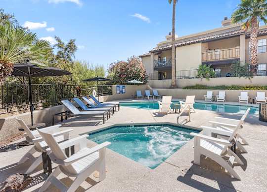 A pool surrounded by chairs and umbrellas.