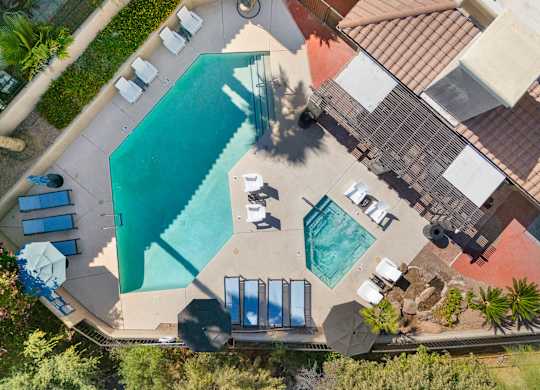 An aerial view of a pool surrounded by sun loungers and umbrellas.