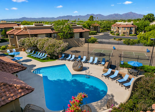 A pool surrounded by lounge chairs and umbrellas.