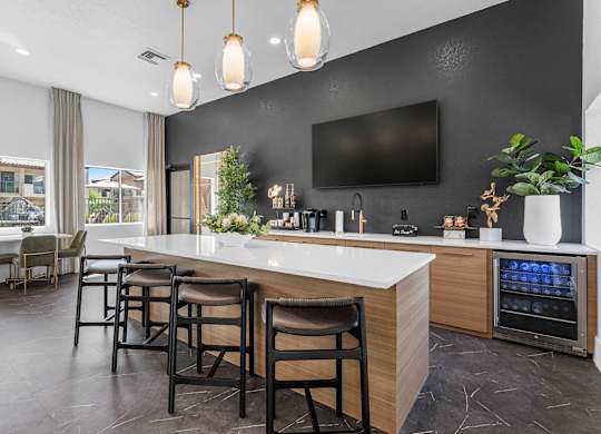 A modern kitchen with a bar area and a television mounted on the wall.