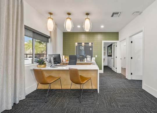 A modern office with a green accent wall and two chairs.