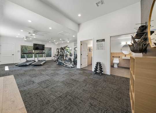 A gym with treadmills, weights, and exercise equipment.