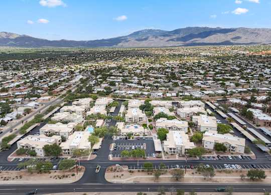 A large suburban area with a parking lot in the foreground and mountains in the background.