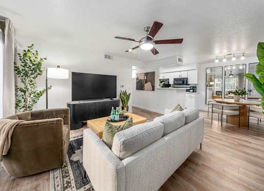 living room with a grey couch, a brown chair, and a wooden floor.