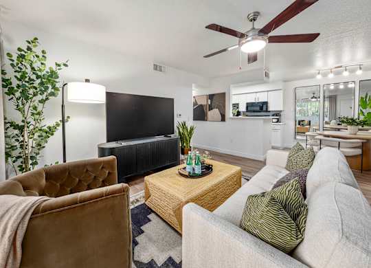 A living room with a brown chair, a grey couch, and a wooden coffee table.