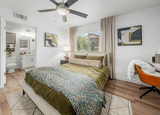 A bedroom with a bed, a chair, and a ceiling fan.