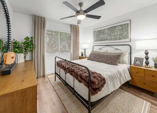 Bedroom with a bed, a ceiling fan, and a wooden dresser.