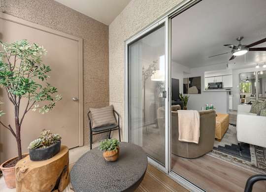 A living room with a glass door leading to a kitchen.