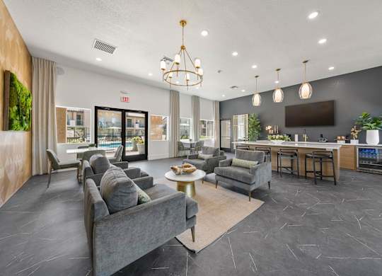 A spacious living room with grey couches and a bar area.