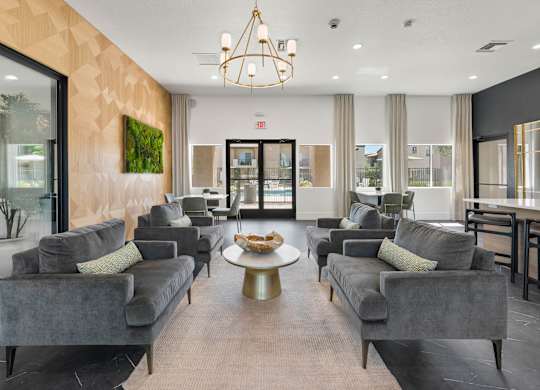 A living room with grey couches and a chandelier.