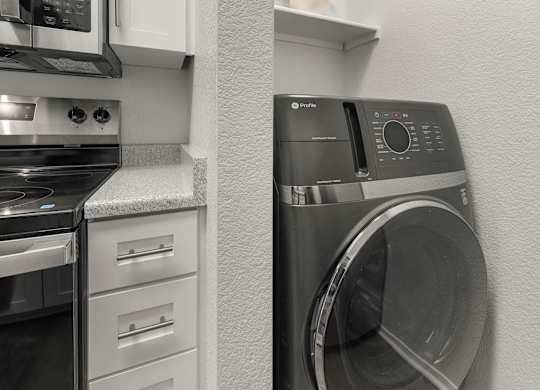 A photo of a washing machine in a kitchen.