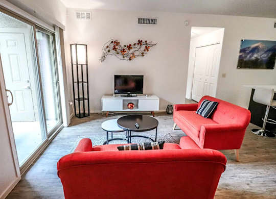 A living room with a red couch and a television.