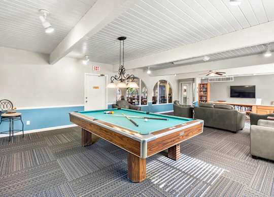 A room with a pool table and a TV.