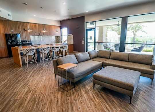 A modern living room with a kitchen area in the background.