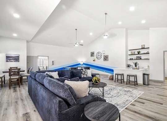 A living room with a grey couch and a blue accent wall.