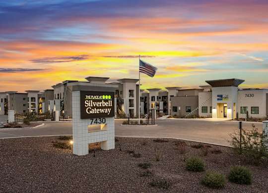 The image shows the Silverbell Gateway with a sunset in the background.