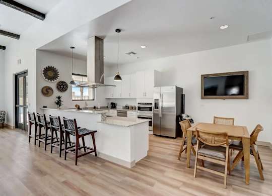 A modern kitchen with wooden floors and a white island.