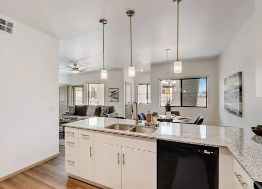 A modern kitchen with a black dishwasher and white cabinets.