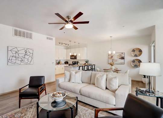 A living room with a white couch and a black chair.