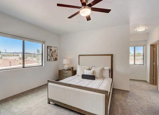 A bedroom with a large bed and a ceiling fan.