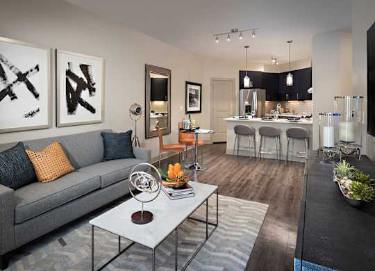 A modern living room with a grey couch and a coffee table in the center.