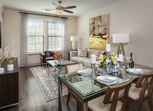 A modern dining room with a glass table and chairs.