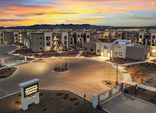 A modern apartment complex with a car parked in front.
