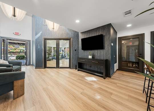 A modern living room with a grey couch and a wooden floor.