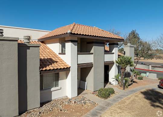 A house with a red tile roof and a white wall.