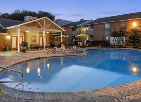A swimming pool in a backyard with a house in the background.
