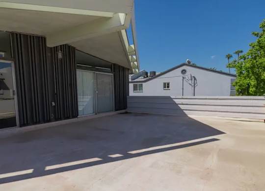 A modern house with a flat roof and a covered patio area.