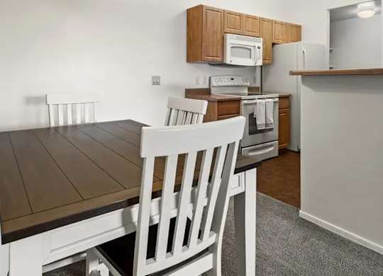 A kitchen with a table and chairs.