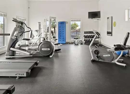 A spacious home gym with a variety of exercise equipment.