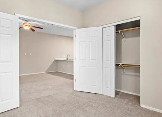 A room with a white door and a ceiling fan.