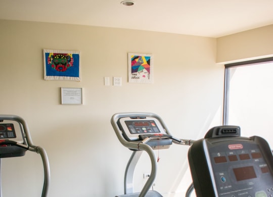 a room with two treadmills and two exercise bikes