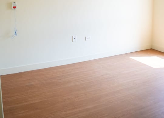 an empty room with white walls and a wooden floor