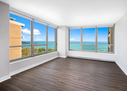 A room with a view of the ocean through large windows.