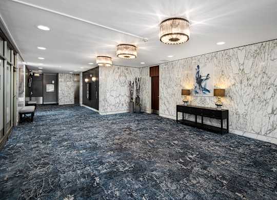 A hallway with marble walls and a statue on the wall.