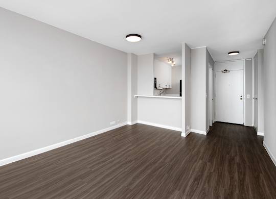 A room with wooden flooring and white walls.