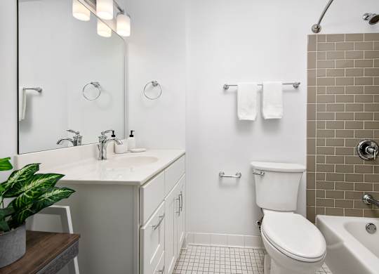 A white toilet sits in a bathroom next to a white sink.
