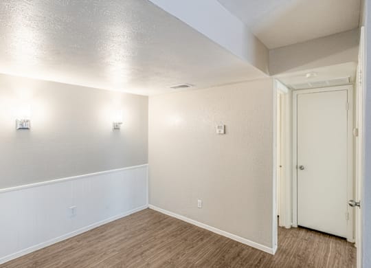 A room with a white door and wall lights.