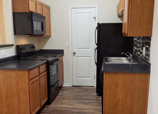 Wooden cabinets and black appliances at Residences at Northgate Crossing, Ohio