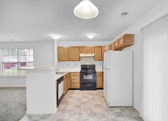 a kitchen with wooden cabinets and a black stove and refrigerator  at Aberdine Place, Georgetown, 40324