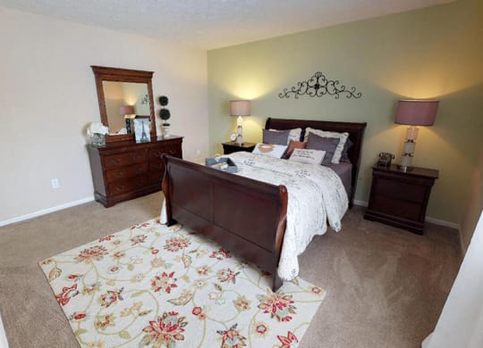 a bedroom with a bed and two dressers  at Hunter's Creek Apartments, Ohio, 45242