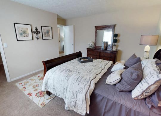 a bedroom with a bed and a dresser in it  at Hunter's Creek Apartments, Cincinnati, OH