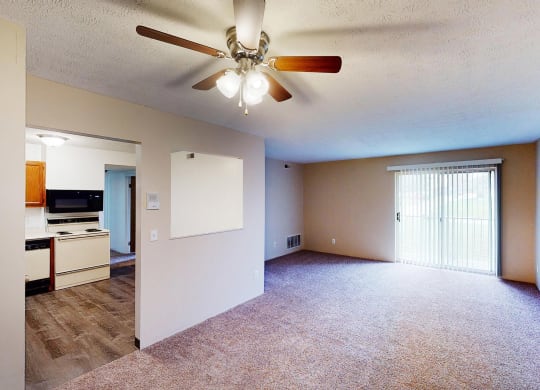 Living room with ceiling light and fan with kitchen nearby at Quail Meadow Apartments, Cincinnati